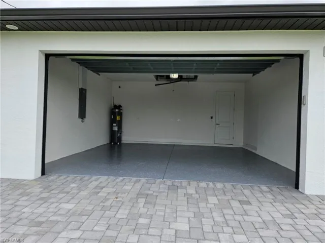 Garage featuring water heater and electric panel