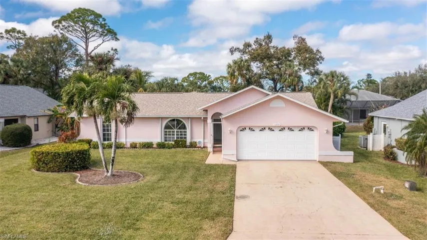 Single story home with a front yard, a garage, and central AC unit