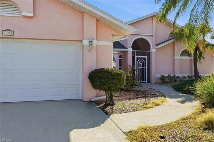 Doorway to entrance, driveway, and an attached 2-car garage