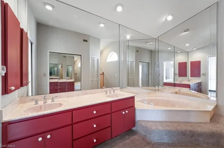 Primary Bathroom with double sinks, soaker tub, and recessed lighting