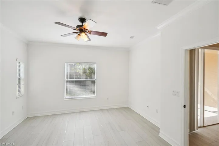 Unfurnished room with ornamental molding, a ceiling fan, and light wood-style floors