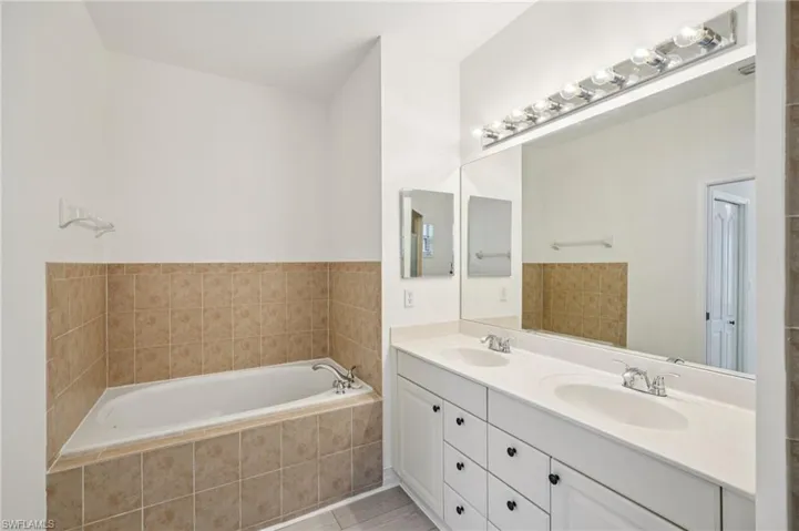 Bathroom featuring double vanity and a garden tub
