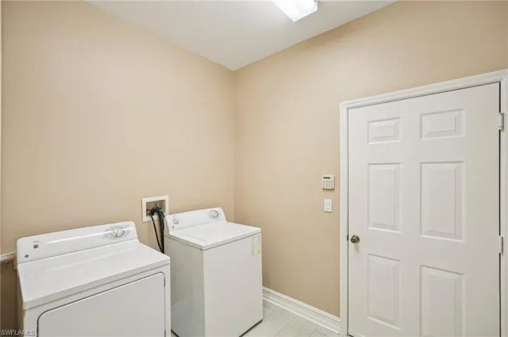 Washroom featuring washing machine and clothes dryer and baseboards