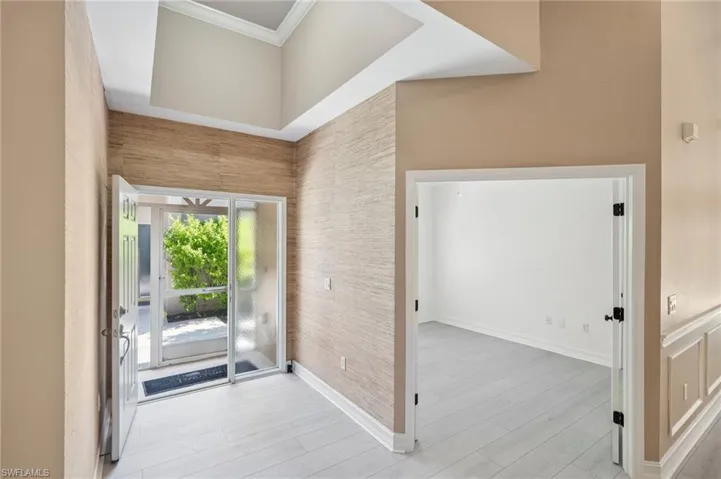 Entrance foyer with ornamental molding and light wood finished floors
