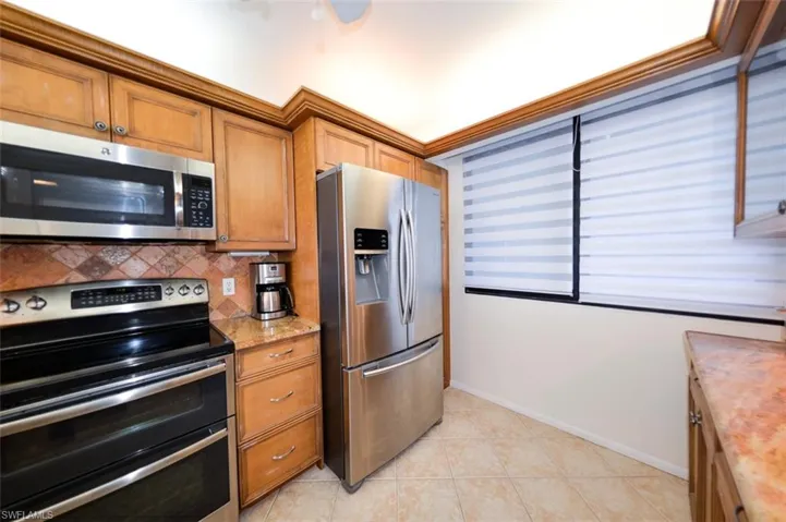 BEAUTIFULLY UPDATED KITCHEN INCLUDES: ZEBRA BLINDS; GRANITE COUNTERTOPS; CABINETRY WITH GLASS-INSERT DOOR ACCENTS AND PULL-OUTS; UNDER-CABINETRY LIGHTING; FULL-HEIGHT TILED BACKSPLASH; LIGHTED TRAY CEILING; STAINLESS STEEL APPLIANCES (DOUBLE OVEN); TILED FLOOR