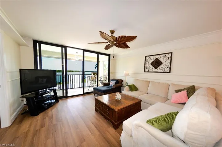 NEWER IMPACT GLASS SLIDING DOORS FROM THE LIVING AREA VIEW OF ESTERO BAY.  LUXURY VINYL TILE WOOD LOOK PLANK FLOORING.  UPDATED FURNISHINGS.  ENTRANCE TO OWNER'S SUITE IS TO LEFT.