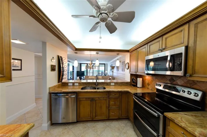UPDATED KITCHEN INCLUDES: GRANITE COUNTERTOPS; PULL-OUTS; UNDER-CABINETRY LIGHTING; FULL HEIGHT TILED BACKSPLASH; LIGHTED TRAY CEILING; STAINLESS STEEL APPLIANCES; UNDER-MOUNT STAINLESS STEEL SINK; HIGH NECK FAUCET; TILED FLOOR