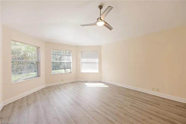 Empty room with light hardwood / wood-style flooring and ceiling fan
