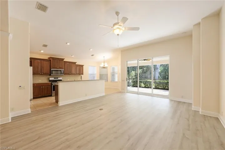Kitchen featuring tasteful backsplash, appliances with stainless steel finishes, a kitchen island, light hardwood / wood-style floors, and pendant lighting