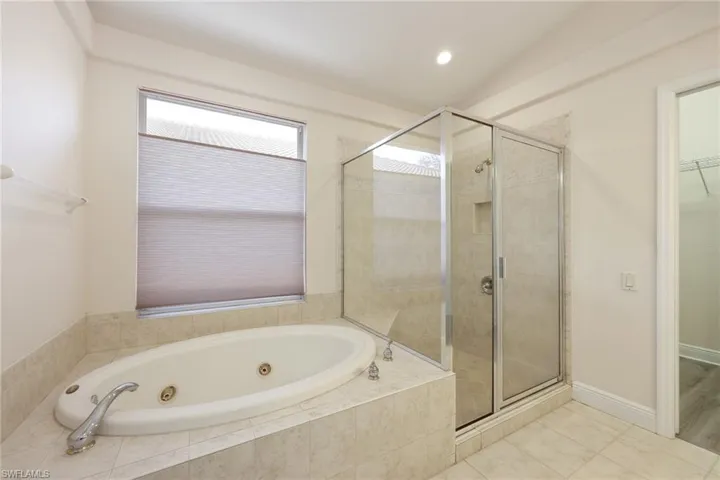 Bathroom featuring tile patterned floors and shower with separate bathtub