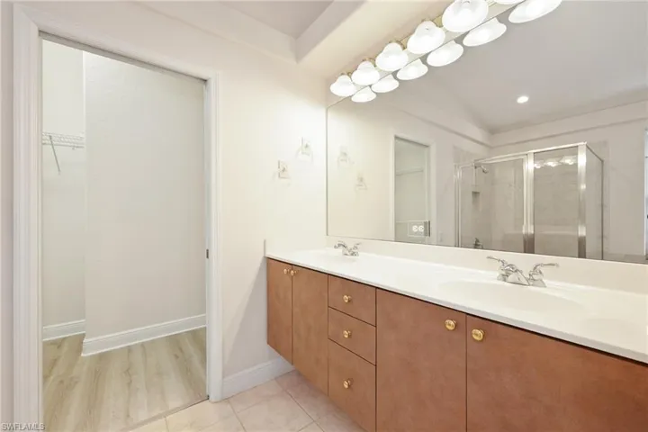 Bathroom with a shower with door, vanity, and hardwood / wood-style flooring