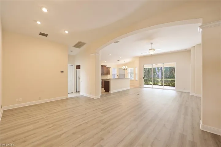 Unfurnished living room with light hardwood / wood-style floors and ceiling fan with notable chandelier