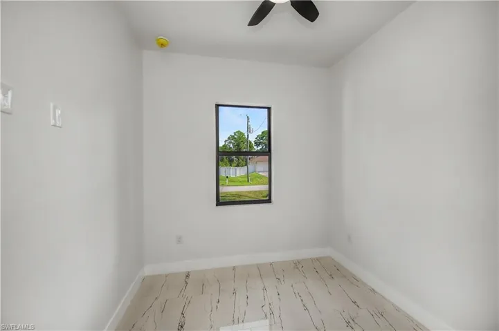 White walls with tile flooring, a single window, and a ceiling fan