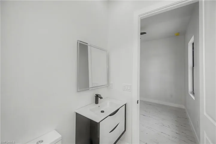 Vanity with black base cabinetry, white countertop, and black faucet
