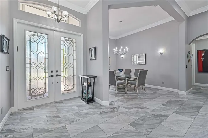 Gorgeous entryway featuring double full glass doors, crown molding with view of your pool/spa as you walk in !