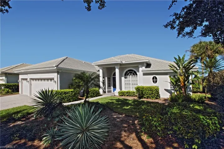 View of front of property featuring stucco siding, a garage, driveway, and a tiled roof