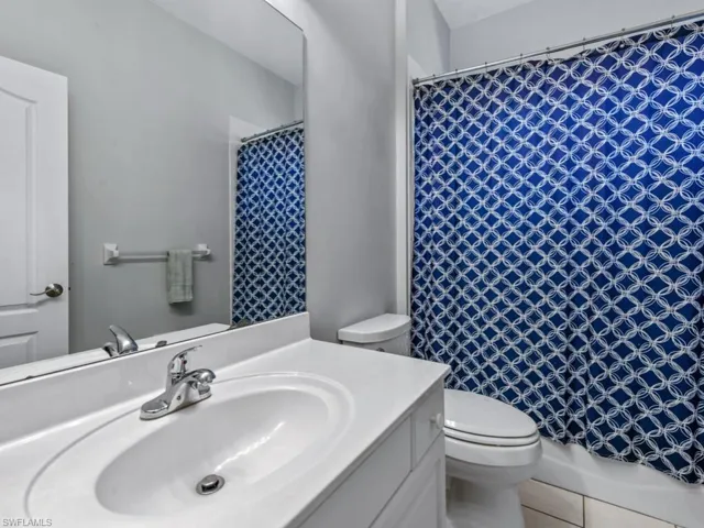 Full bathroom featuring toilet, tile patterned flooring, and vanity