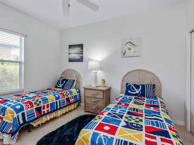 Bedroom with ceiling fan and tile patterned floors