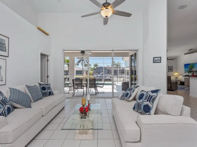 Tiled living area with ceiling fan and a high ceiling