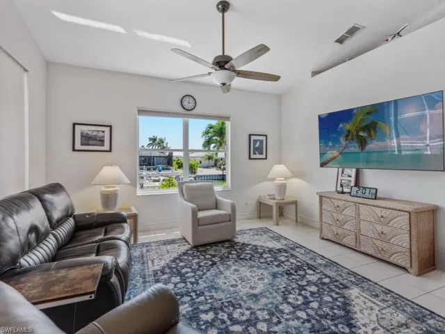 Tiled living area with baseboards, visible vents, and a ceiling fan