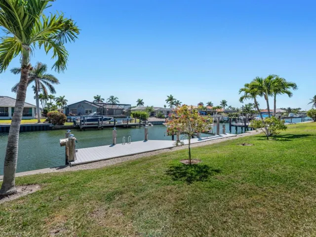 View of dock featuring a residential view, a water view, and a yard