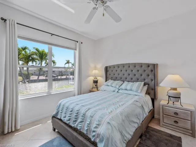 Bedroom with light tile patterned flooring, baseboards, and ceiling fan