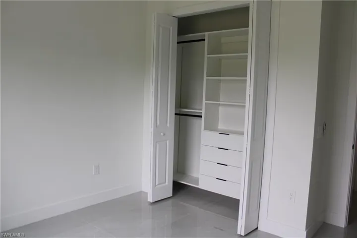 Custom closet system featuring built-in shelving, four drawers, and dual hanging rods