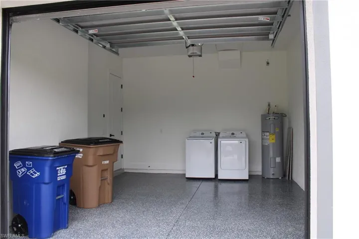Spacious garage featuring a durable epoxy floor coating and crisp white walls