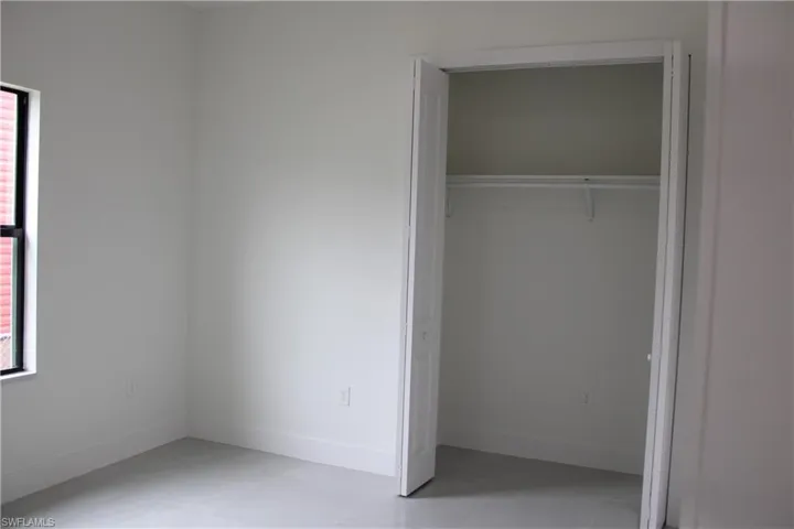 White-painted room featuring a bi-fold closet with a white wire shelf and hanging rod