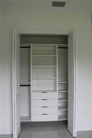 Custom closet system featuring built-in shelving, four drawers with integrated pulls, and dual hanging rods