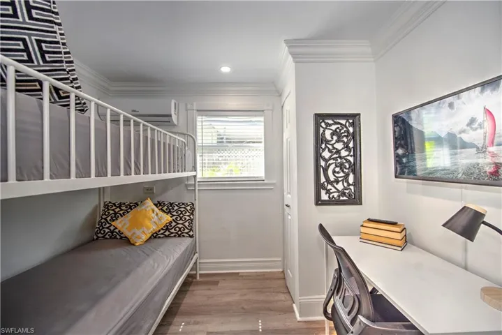 Bedroom featuring wood-type flooring and a wall unit AC