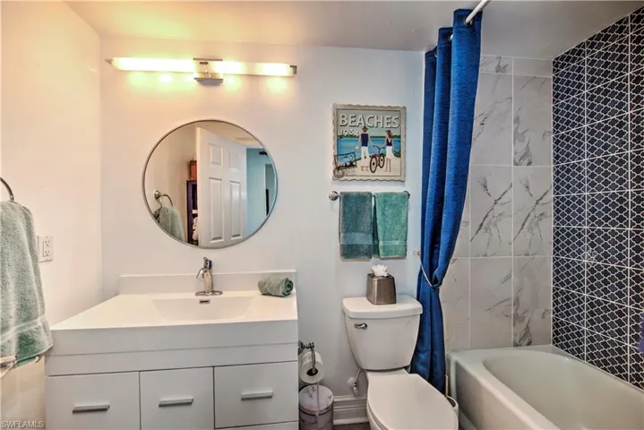 Bathroom with tiled shower / bath and toilet