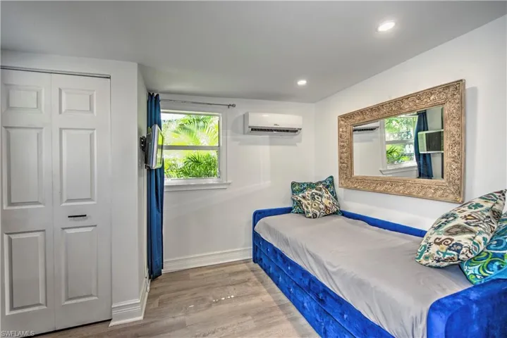 Bedroom featuring ornamental molding, an AC wall unit, and hardwood / wood-style floors