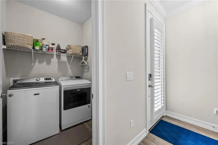 Laundry room featuring ornamental molding, light hardwood / wood-style flooring, and independent washer and dryer