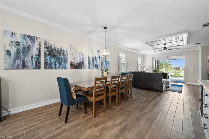 Dining space with ceiling fan, dark hardwood / wood-style floors, and ornamental molding