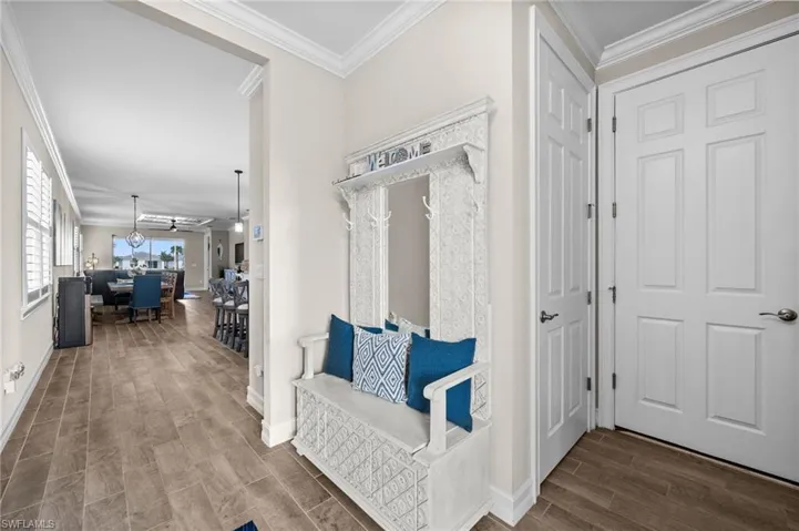 Hallway with wood-type flooring and crown molding