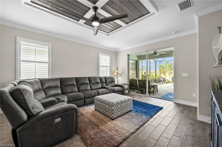 Living room featuring hardwood / wood-style flooring, crown molding, and ceiling fan