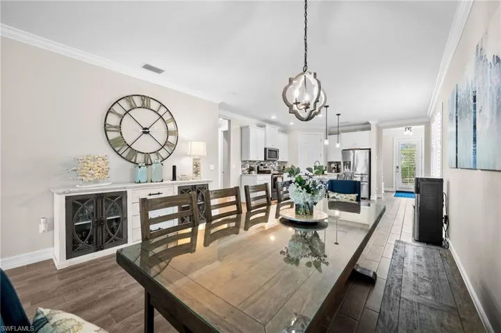 Dining space with ornamental molding, a chandelier, and dark hardwood / wood-style flooring