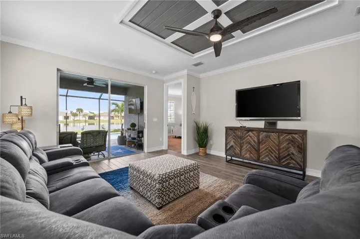Living room featuring light hardwood / wood-style floors, crown molding, and ceiling fan