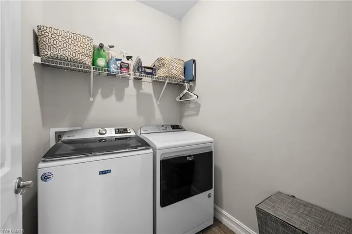Laundry area with washer and dryer and wood-type flooring