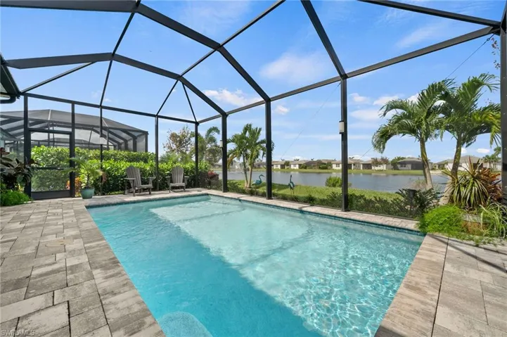 View of pool featuring a lanai, a water view, and a patio area