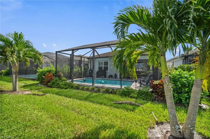 View of swimming pool featuring a lanai and a lawn