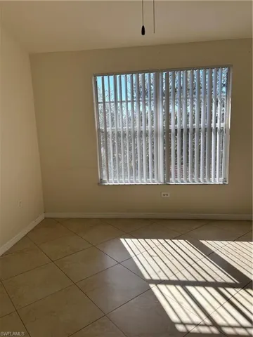 Tiled empty room featuring baseboards
