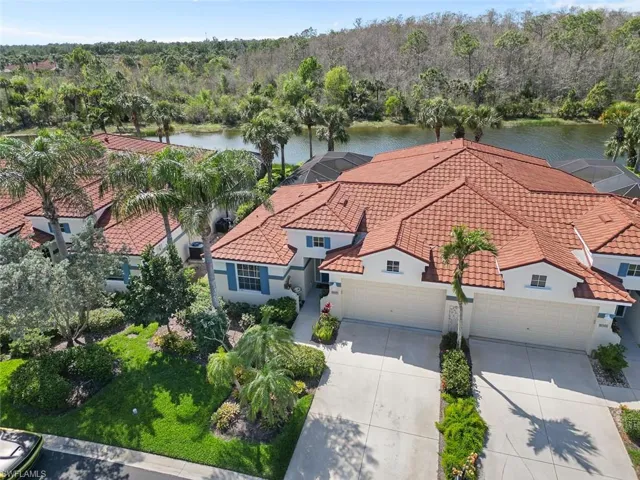 Birds eye view of property with a water view and a view of trees