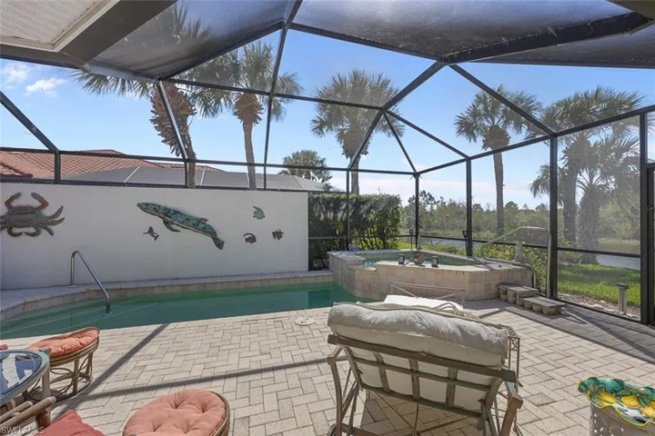 Outdoor pool with a lanai, a patio, and an in ground hot tub