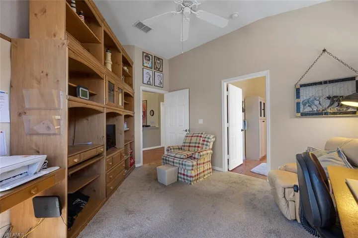 Sitting room featuring lofted ceiling, carpet, visible vents, and a ceiling fan