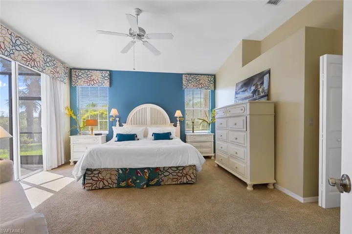 Bedroom with visible vents, baseboards, a ceiling fan, light colored carpet, and access to exterior