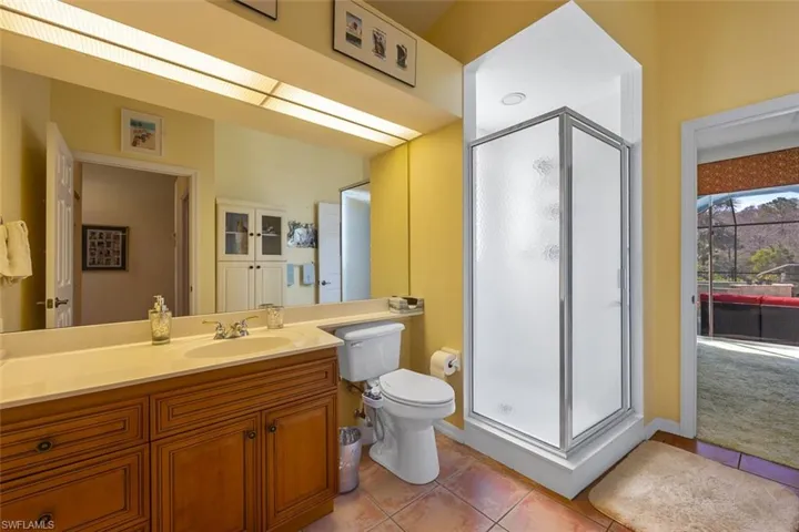 Bathroom with toilet, tile patterned flooring, vanity, and a shower stall