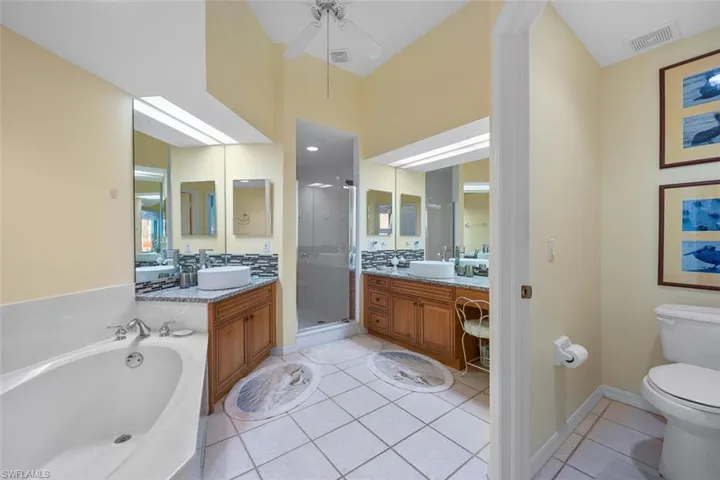 Full bathroom featuring visible vents, toilet, a stall shower, vanity, and tile patterned floors