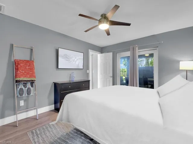 Bedroom featuring access to outside, wood finished floors, and ceiling fan